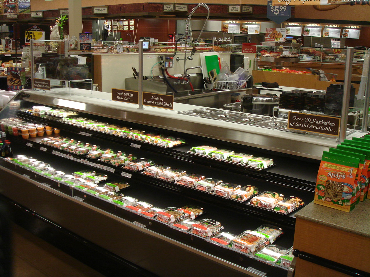 Kroger店内の寿司バーを斜めから撮影。寿司が並ぶショーケースと奥の作業場
